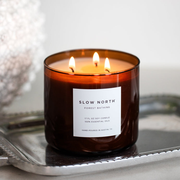 Forest Bathing three-wick candle in an amber glass jar